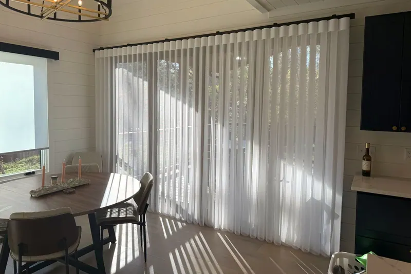 Afternoon light glowing through closed SmartDrape fabric vanes on a wall of glass