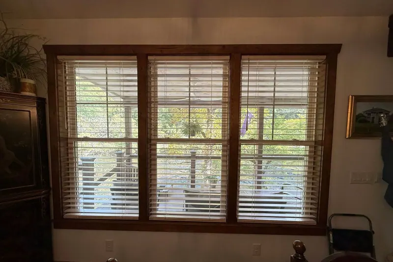 Wood blinds on three windows with stained wood trim